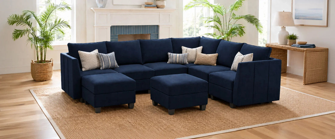 Belffin-Charcoal-grey-modular-sectional-sofa-with-footstools-in-a-modern-living-room-with-large-windows-and-a-sea-view.