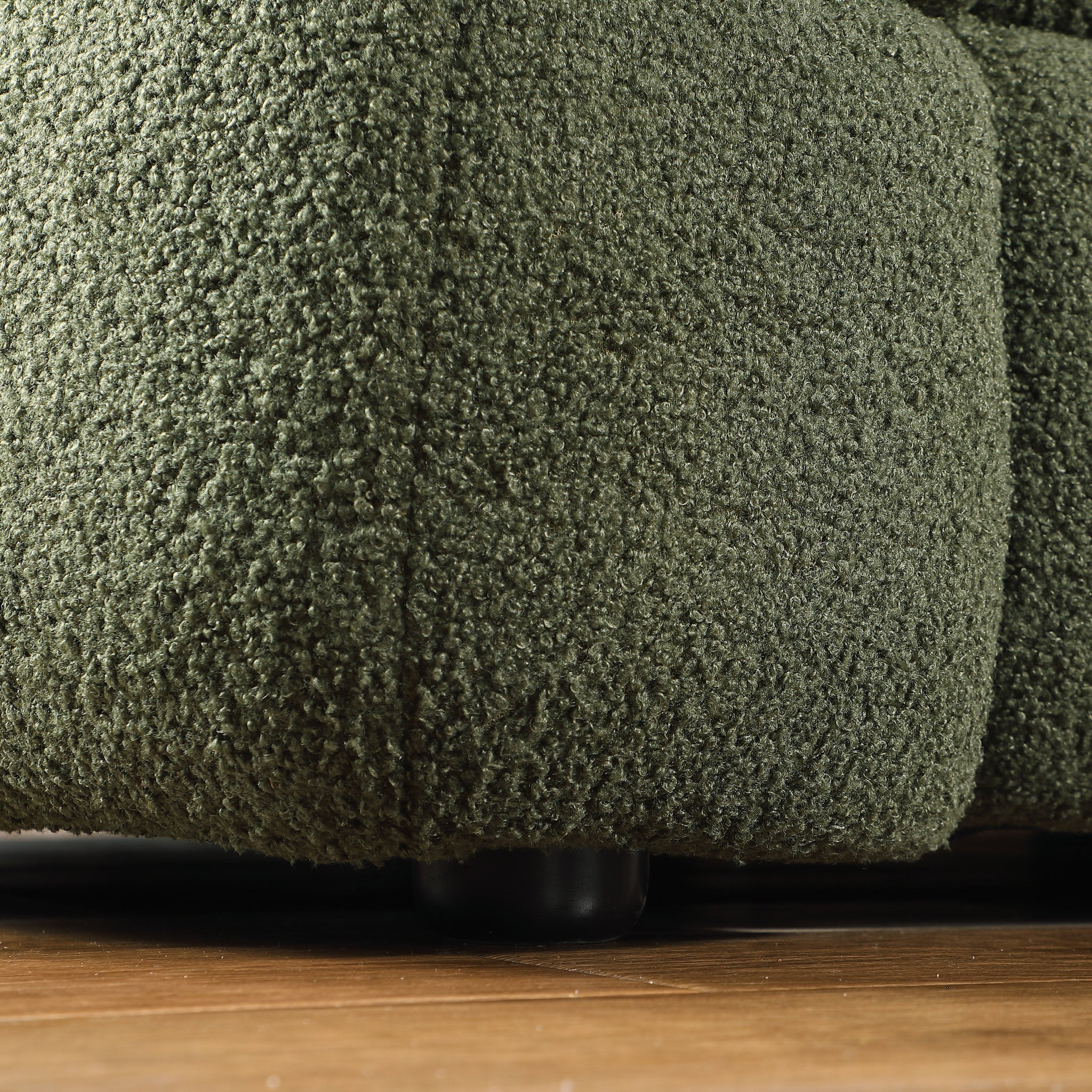 Extreme close-up of the olive green bouclé fabric texture.